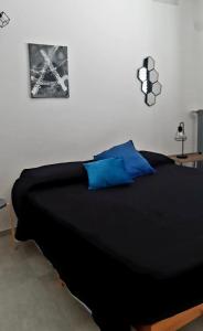 莱切ANDIRIVIENI☆LECCE ☆CASA VACANZE LECCE的一间卧室配有带蓝色枕头的黑色床