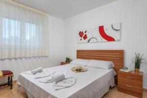 卡尔佩Villa Caleta - PlusHolidays的一间卧室,配有一张床,上面有帽子