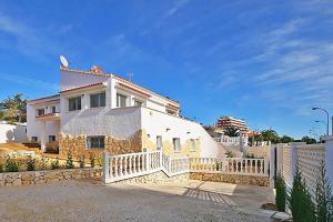 卡尔佩Villa Calalga - PlusHolidays的前面有栅栏的白色房子