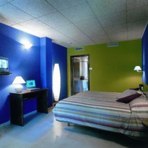 奥洛特坎布兰科酒店的蓝色和绿色的卧室配有一张床和一张书桌