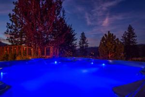 科斯戈尔德Alpine 4 Bedroom Retreat with Hot tub and Pool table的夜晚在院子里的一个蓝色热水浴缸