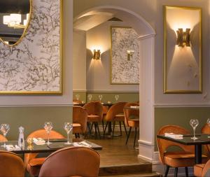 泰恩河畔纽卡斯尔奥斯本酒店的一间带桌椅和镜子的用餐室
