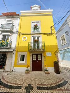 塞图巴尔Baia do Mundo的前面有鲜花的黄色建筑