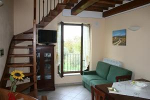 巴尼圣菲利波Casa Vacanze San Francesco的客厅设有绿色沙发和楼梯。