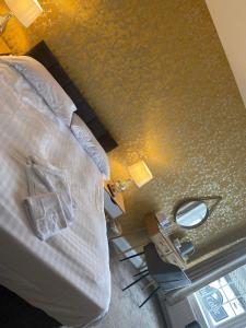 滨海纽比金老船酒店的一间卧室配有一张床和一张带镜子的桌子