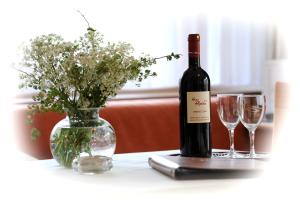布雷根茨沃尔德地区奥Haus Alpina的桌子上放有一瓶葡萄酒和两杯酒