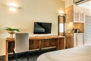 威廉斯塔德Bayside Boutique Hotel - Blue Bay Golf & Beach Resort的客房设有电视和带椅子的书桌