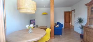 圣地亚哥－德孔波斯特拉Casa Vilas, Santiago de Compostela的一间带木桌和黄色椅子的用餐室