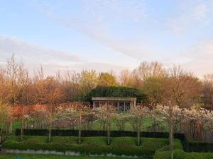 圣尼古拉Domein Den Buiten Bed And Breakfast DnD的花园,带草屋顶的建筑