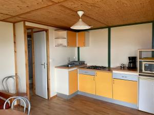 坎波莫罗Lavallee的厨房设有黄色和白色的橱柜和木制天花板。