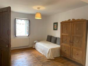 Alameda del ValleLa Toscana en Lozoya的一间卧室配有一张床、一个梳妆台和一扇窗户。