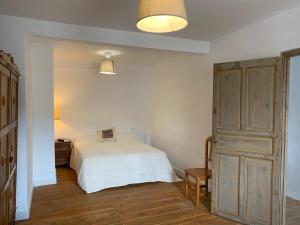 Alameda del ValleLa Toscana en Lozoya的卧室配有白色的床,铺有木地板