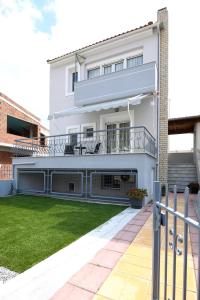 伊拉克里萨Villa Bolero的带阳台和庭院的白色房屋