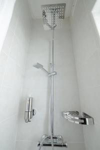 斯利马Di Valentina Boutique Living的浴室铺有白色瓷砖,设有淋浴。