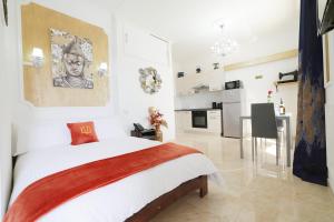 斯利马Di Valentina Boutique Living的一间白色卧室,配有一张大床和一个厨房