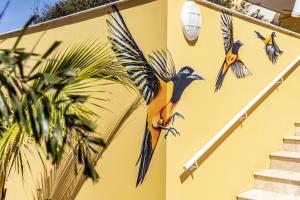 威廉斯塔德Bayside Boutique Hotel - Blue Bay Golf & Beach Resort的建筑物一侧鸟儿的绘画