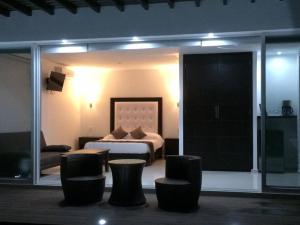 Los PascualesLuxurious Surf Resort in Pascuales Mexico Room 3的酒店客房,配有一张床和一些椅子
