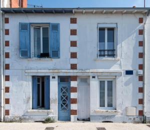 拉罗谢尔La Mariennée的白色的房子,有蓝色的窗户和蓝色的门