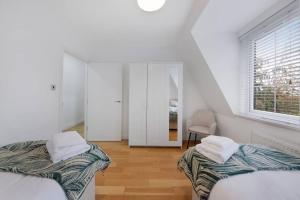彼索普斯托福Roomy One bed loft apartment的白色的客房设有两张床和窗户。
