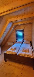 Crni VrhApartmani Prica的木制阁楼卧室配有一张床
