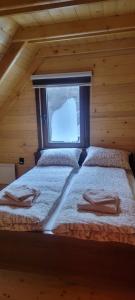 Crni VrhApartmani Prica的小木屋内的两张床,设有窗户