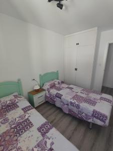 德拉塞尔瓦港L'Olivar的卧室内的两张床,配有紫色和白色床单