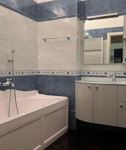 博洛尼亚Piazza Maggiore Luxury Apartment的带浴缸、水槽和镜子的浴室