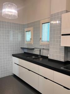 博洛尼亚Piazza Maggiore Luxury Apartment的厨房配有白色橱柜和黑色台面