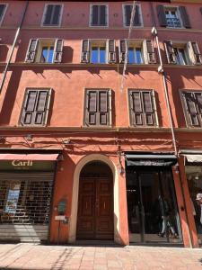 博洛尼亚Piazza Maggiore Luxury Apartment的橙色的建筑,设有棕色的门和窗户