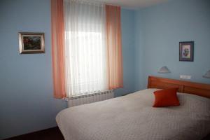 布莱德Vila Krivec的一间卧室配有床和橙色窗帘的窗户