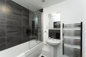 曼彻斯特High Street Town House的浴室配有盥洗盆、浴缸和卫生间。
