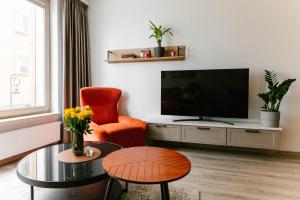 什切青Apartament Środowa by Prestige Home的客厅配有电视、椅子和桌子