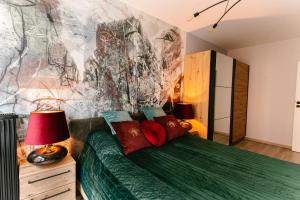 什切青Apartament Środowa by Prestige Home的卧室配有一张绿色的床,墙上挂有绘画作品
