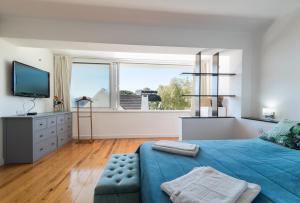 卡帕里卡海岸Caparica Dream Vila的一间卧室设有蓝色的床和大窗户