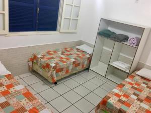 马卡埃Pousada Bem Brasil的一间设有两张床的房间和一个橱柜