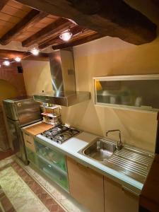 蒙特普齐亚诺The Small Sweet House的厨房配有水槽和炉灶