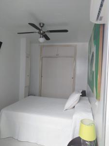 阿尔么丽亚PAUPET的卧室配有白色的床和吊扇