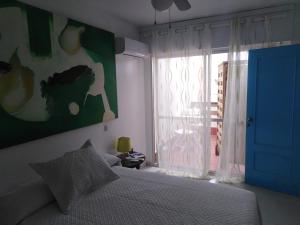 阿尔么丽亚PAUPET的一间卧室配有一张带蓝色门和窗户的床