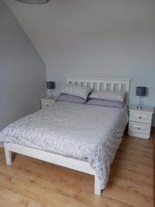 恩尼斯Larchlodge的一间卧室配有白色床和2个床头柜