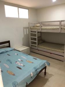 萨利纳斯Salinas Bay Suite的一间卧室配有双层床和一张带蓝色棉被的床。