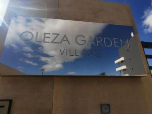 弗拉门卡海滩Oleza Garden Village , Apartment Ines的读着gleza花园村的建筑上的标志