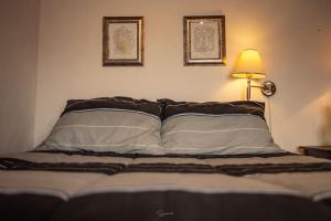 Cabaña Corazon de Calixto的卧室配有一张墙上有两张照片的床。