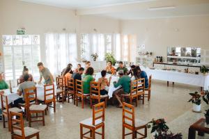 戈亚斯州上帕莱索Hotel Fazenda Bona Espero的一群坐在房间里桌子的人
