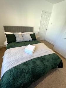 滨海绍森德Seaforth Deluxe 2 bedroom apartment at Rockman Luxury Short Stays Lets and Accommodation的一间卧室配有一张带绿毯的大床
