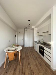 布宜诺斯艾利斯Monoambiente Urquiza的一间厨房,内设白色橱柜和一张桌子