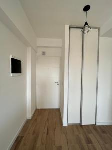 布宜诺斯艾利斯Monoambiente Urquiza的一个空房间,有白色的衣柜和门