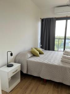 布宜诺斯艾利斯Monoambiente Urquiza的白色的卧室设有床和窗户