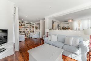 埃斯托利尔Casa da Praia的白色的客厅配有沙发和桌子