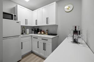 珊瑚角Tropical Paradise的白色的厨房配有白色橱柜和冰箱。