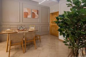 诺阿瑟Luxury Apartment Airport的一间配备有桌椅和植物的房间